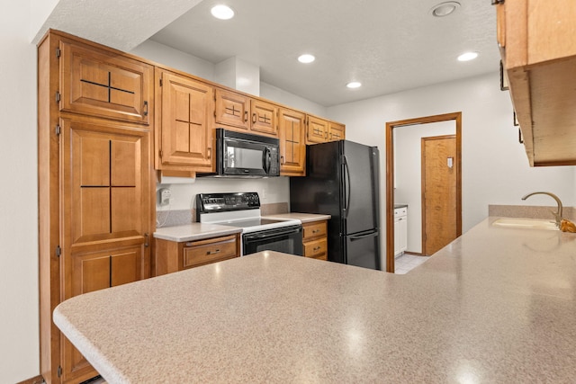 kitchen featuring sink, kitchen peninsula, and black appliances