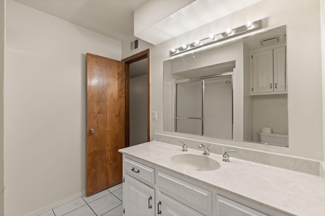 bathroom featuring an enclosed shower, vanity, tile patterned floors, and toilet