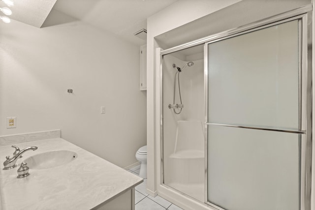 bathroom featuring vanity, toilet, tile patterned flooring, and a shower with door