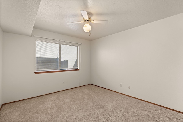 unfurnished room featuring ceiling fan, light colored carpet, and a textured ceiling