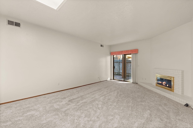 carpeted spare room with a fireplace