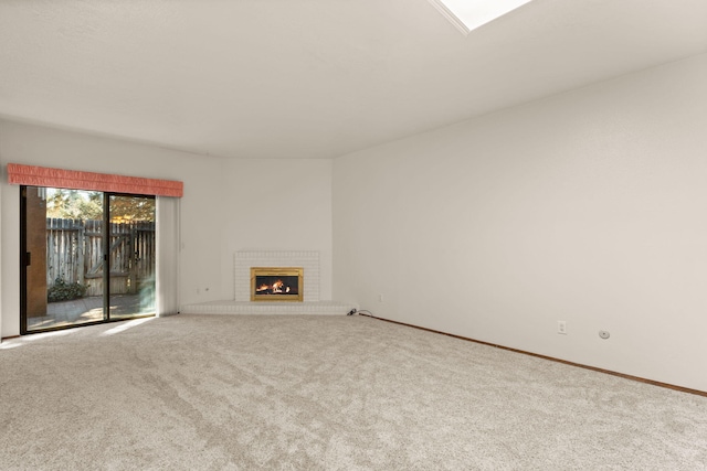 unfurnished living room with a brick fireplace and carpet floors