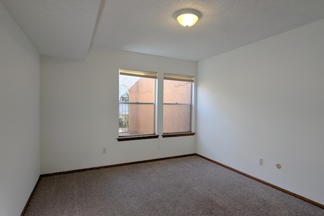 unfurnished room with a textured ceiling and carpet