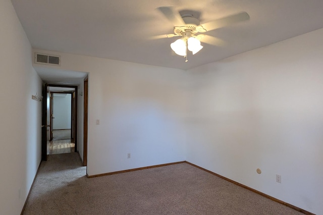 spare room featuring ceiling fan and carpet