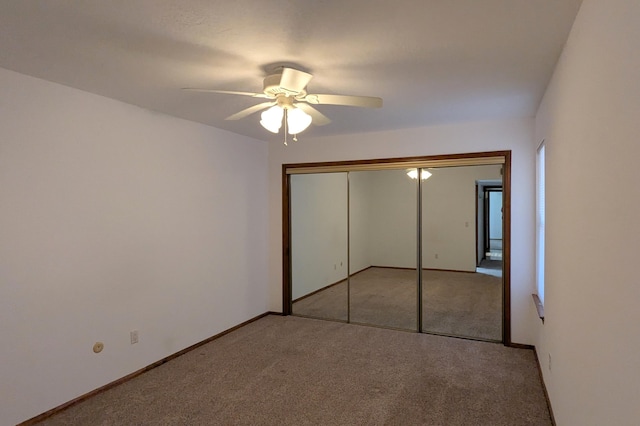 unfurnished bedroom with ceiling fan, light colored carpet, and a closet