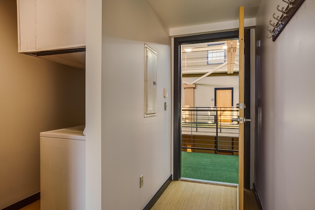 hallway with washer / dryer and light hardwood / wood-style flooring