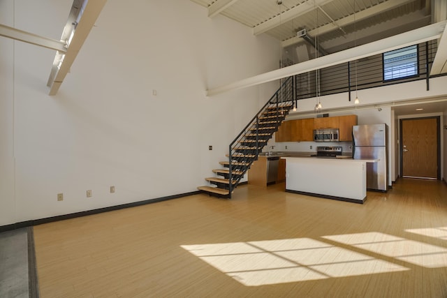 interior space featuring light hardwood / wood-style floors and a high ceiling