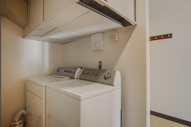 laundry area with cabinets, washer and clothes dryer, and light hardwood / wood-style floors