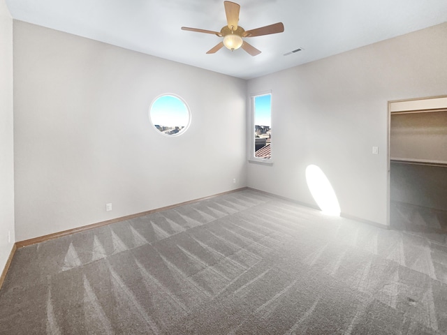 carpeted empty room featuring ceiling fan