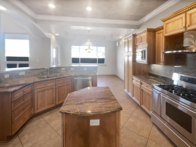 kitchen featuring wall chimney exhaust hood, sink, a center island, pendant lighting, and stainless steel appliances