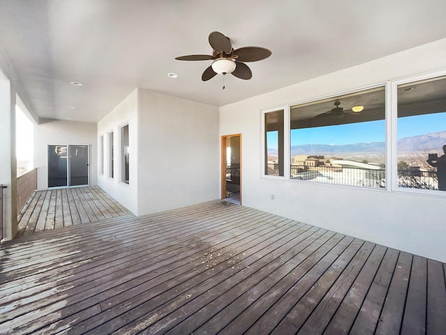 wooden deck featuring a mountain view and ceiling fan