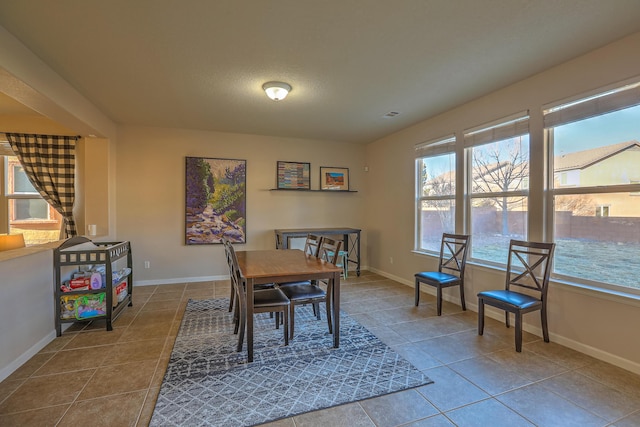 dining room featuring tile patterned flooring and a textured ceiling