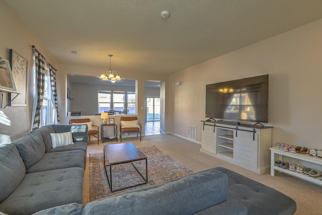 living room featuring light carpet, a textured ceiling, and an inviting chandelier