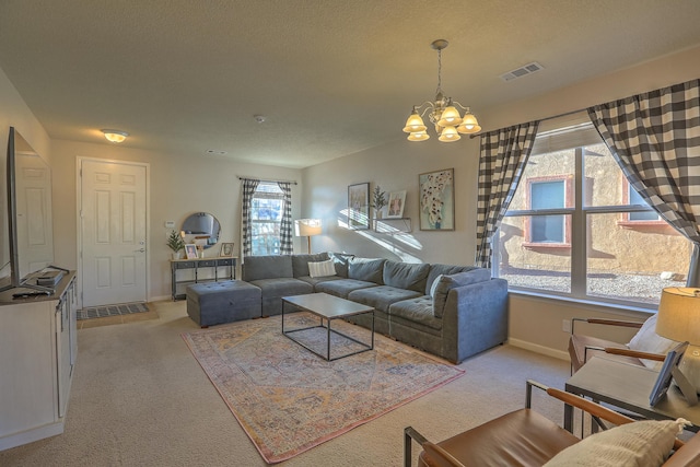 carpeted living room with a chandelier and a textured ceiling