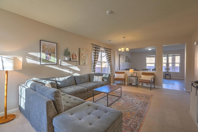 carpeted living room with a notable chandelier, a textured ceiling, and a healthy amount of sunlight