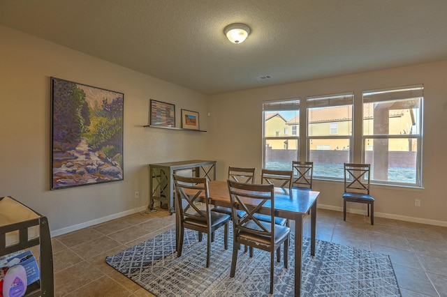 tiled dining area featuring a textured ceiling