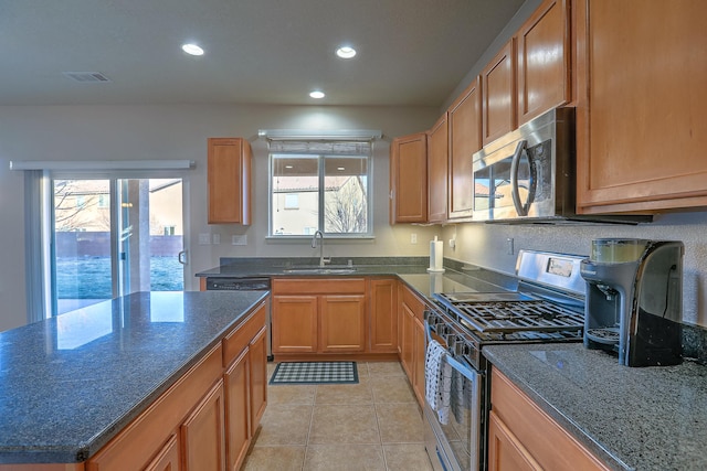 kitchen featuring light tile patterned flooring, appliances with stainless steel finishes, sink, and a wealth of natural light