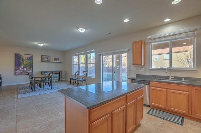 kitchen with light tile patterned flooring, a center island, sink, and stainless steel dishwasher