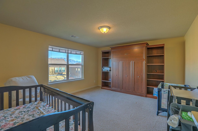 bedroom featuring light colored carpet and a textured ceiling