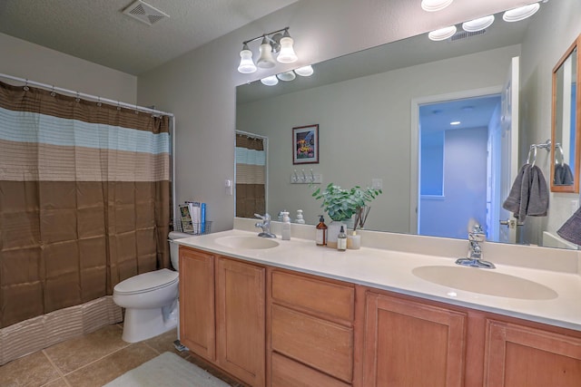 bathroom with toilet, a textured ceiling, vanity, curtained shower, and tile patterned flooring