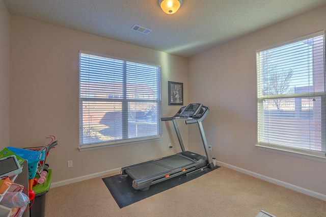 workout room with carpet and a textured ceiling