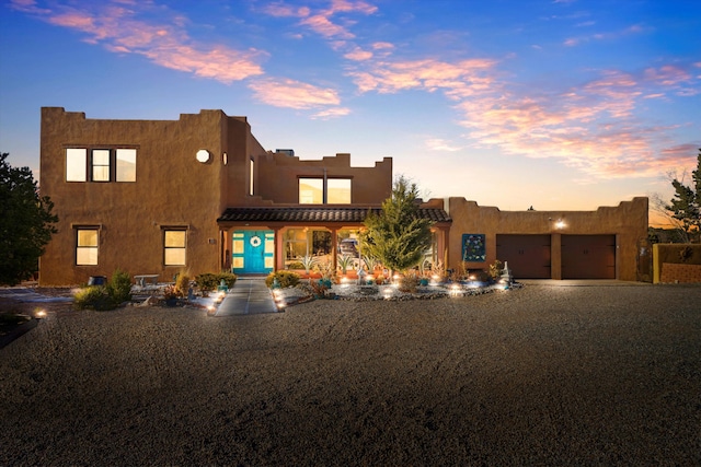 pueblo revival-style home with a garage