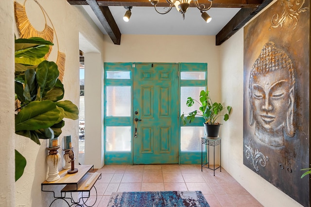 tiled foyer with a chandelier and beamed ceiling