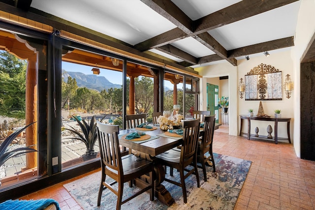 dining room featuring a mountain view and beamed ceiling