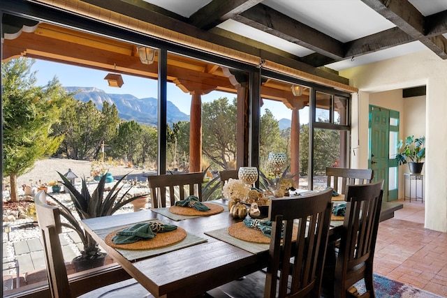 sunroom with a mountain view and beam ceiling