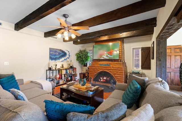 living room with a brick fireplace, beamed ceiling, and ceiling fan