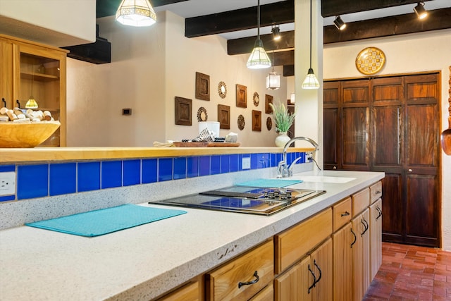 kitchen with black electric cooktop, decorative light fixtures, sink, and beamed ceiling