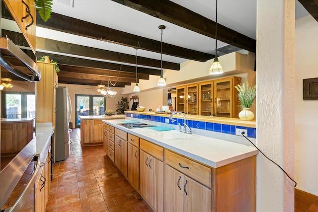 kitchen featuring sink, stainless steel fridge, ceiling fan, decorative light fixtures, and black cooktop