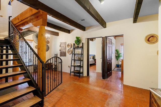 stairs featuring an inviting chandelier and beam ceiling