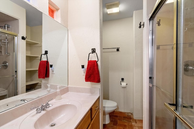 bathroom with vanity, toilet, and a shower with door