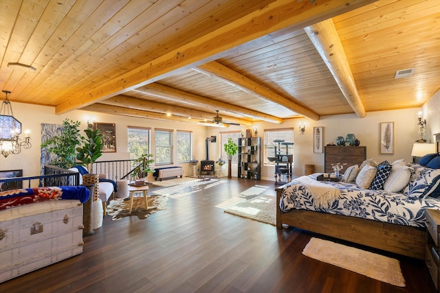 bedroom featuring dark wood-type flooring, wooden ceiling, a wood stove, a notable chandelier, and beamed ceiling