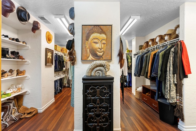 spacious closet with dark wood-type flooring