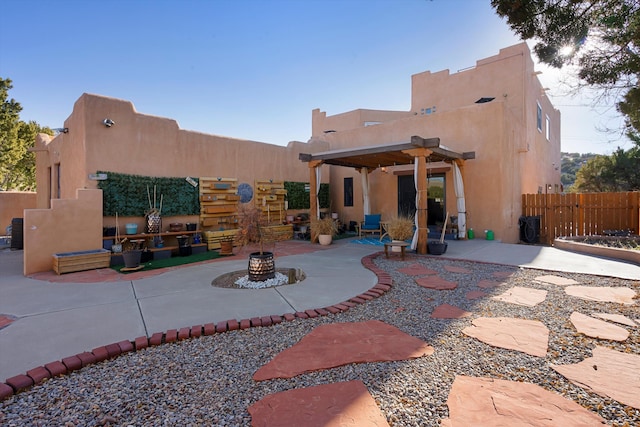 rear view of property with a patio and a pergola