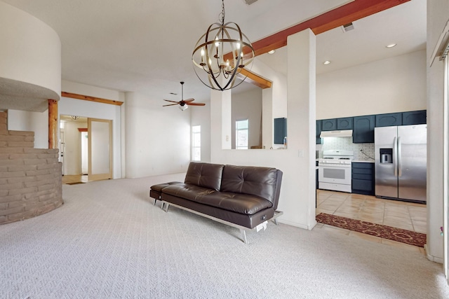 carpeted living room featuring a towering ceiling and ceiling fan with notable chandelier