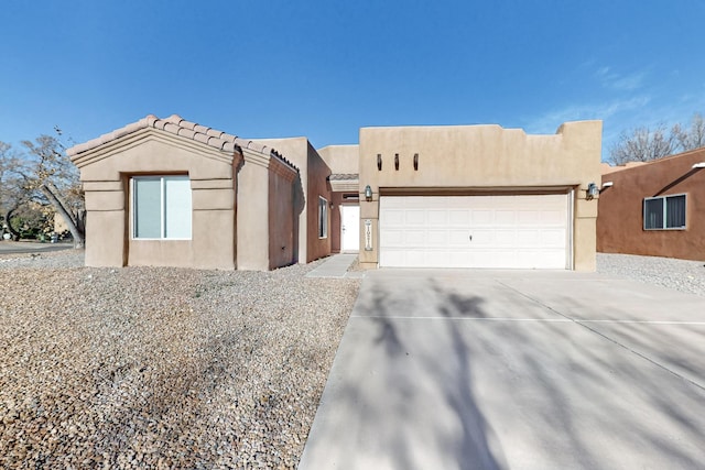 pueblo-style house featuring a garage