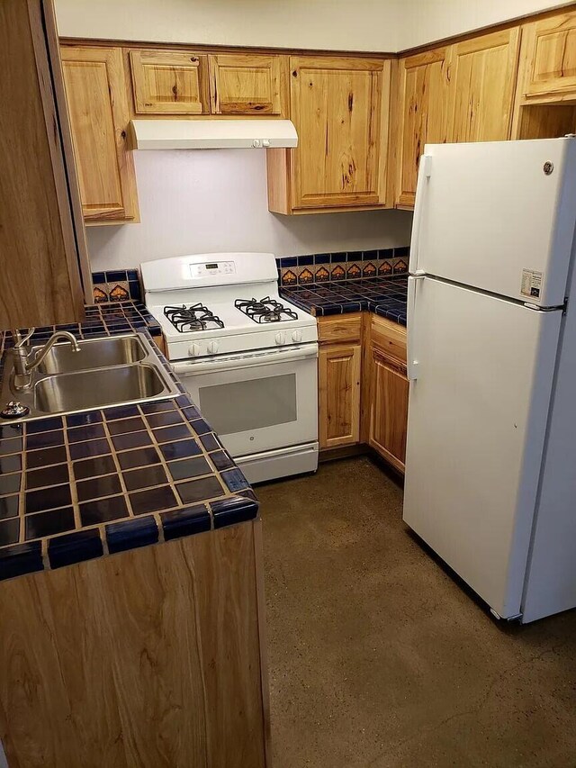 kitchen featuring sink, white appliances, and tile countertops