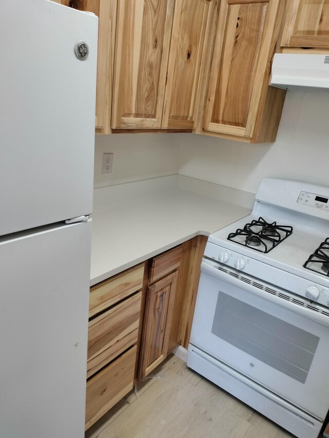 kitchen featuring white appliances and light hardwood / wood-style flooring