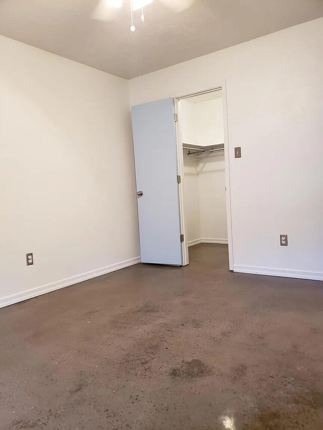 unfurnished bedroom with ceiling fan and a closet