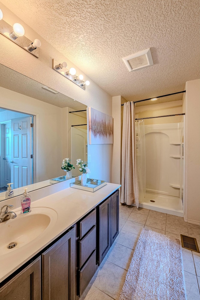 bathroom featuring tile patterned flooring, vanity, a textured ceiling, and a shower with curtain