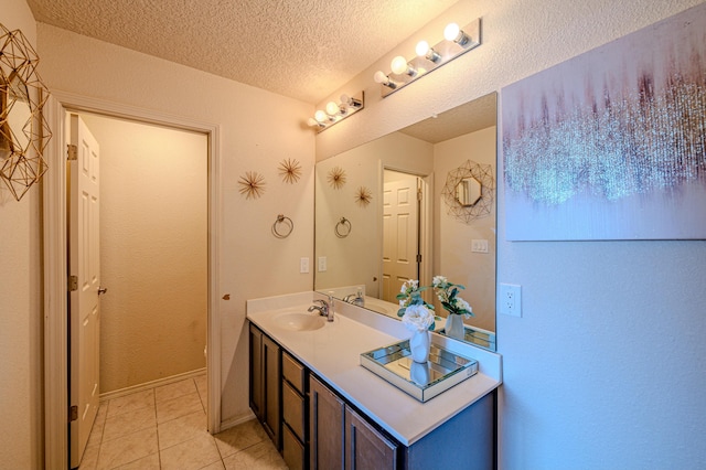 bathroom featuring vanity, tile patterned floors, and a textured ceiling