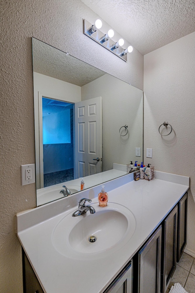 bathroom with tile patterned flooring, vanity, and a textured ceiling