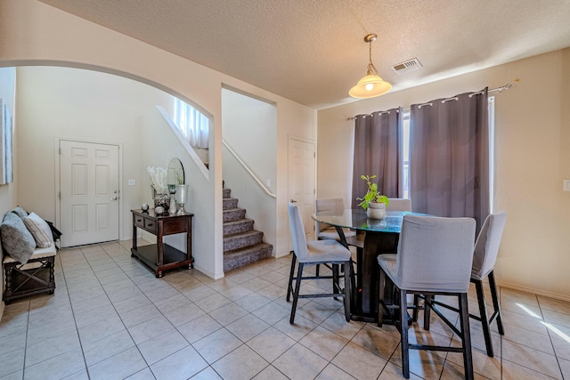 tiled dining area with a textured ceiling