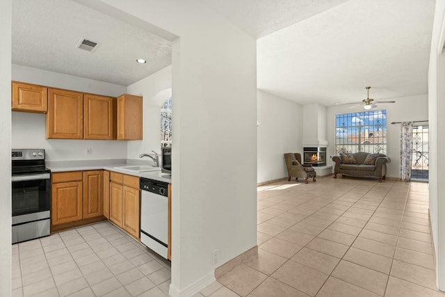 kitchen with sink, a textured ceiling, light tile patterned floors, electric range, and dishwasher