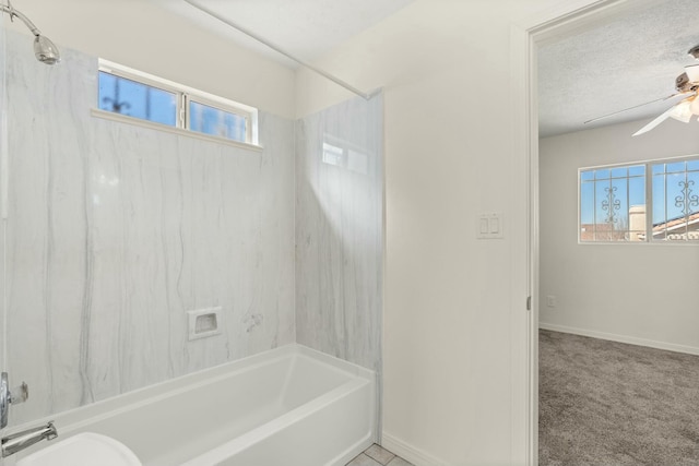 bathroom with ceiling fan, tiled shower / bath combo, and a textured ceiling