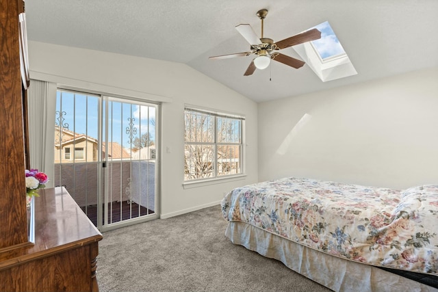 bedroom featuring ceiling fan, lofted ceiling with skylight, carpet flooring, a textured ceiling, and access to outside