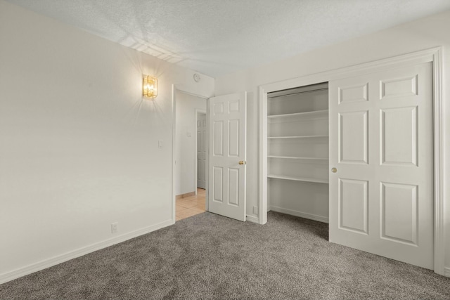 unfurnished bedroom featuring light colored carpet, a closet, and a textured ceiling